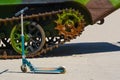 KidsÃ¢â¬â¢ scooter. A caterpillar track of a military vehicle.